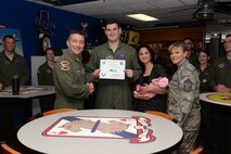 Capt. Kevin A. Calloway, center, 434th Flying Training Squadron assistant operations officer and T-6 instructor pilot, poses with Col. Brian Hastings, left, 47th Flying Training Wing commander, his wife Anamarky and child Camila, right, and Chief Master Sgt. Teresa Clapper, far right, 47th FTW command chief, after accepting the XLer of the Week award here May 20, 2015. The XLer is a weekly award chosen by wing leadership and is presented to those who consistently make outstanding contributions to their unit and Laughlin. (U.S. Air Force photo by Airman Brandon May)(Released)