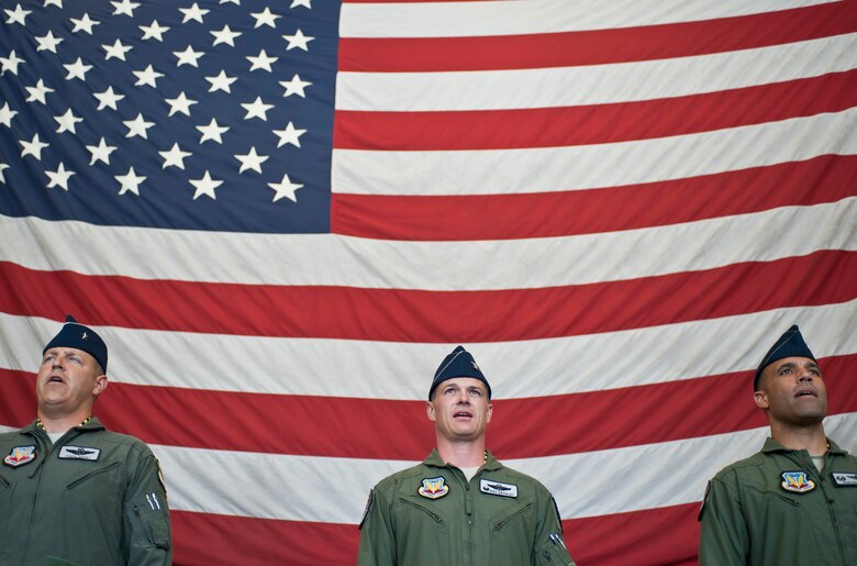 Brig. Gen. Christopher Short, Col. Michael Drowley and Col. Adrian Spain sing the Air Force song at the end of the U.S. Air Force Weapons School’s change of command ceremony at Nellis Air Force Base, Nev., May 26, 2015. Short is the 57th Wing commander, Drowley is the USAFWS’s commandant, and Spain is the USAFWS’s former commandant. (U.S. Air Force photo by Staff Sgt. Siuta B. Ika)