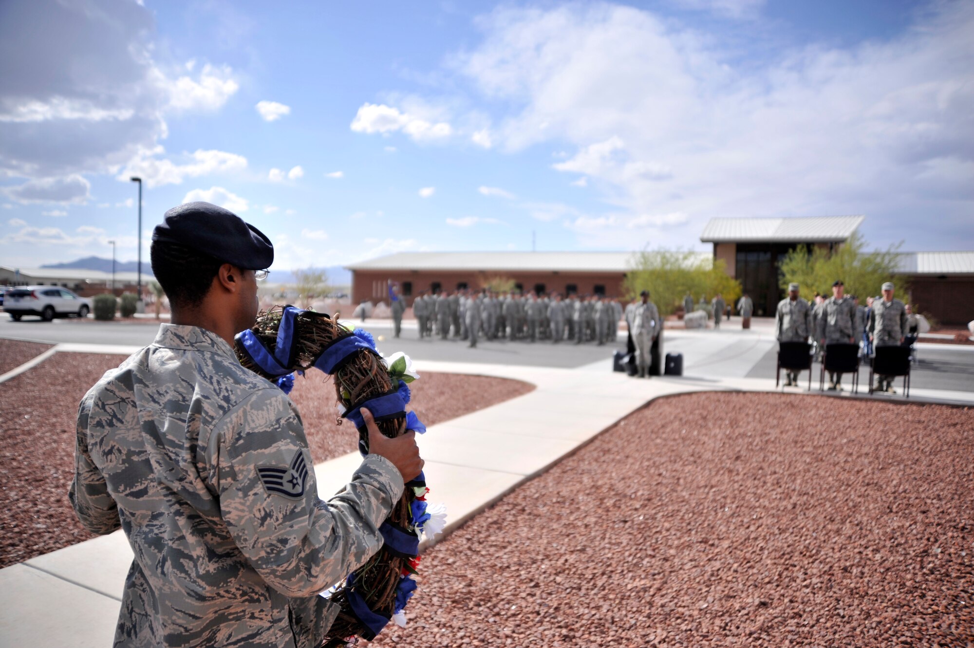 Staff Sgt. James Jackson, 799th Security Forces Squadron element leader, holds a wreath during a retreat ceremony May 14, 2015, at Creech Air Force Base, Nevada. During National Police Week, security forces Airmen and local law enforcement personnel around the Air Force take part in various ceremonies to show their support for fallen law enforcement officials from across the nation. (U.S. Air Force photo by Airman 1st Class Christian Clausen/Released)