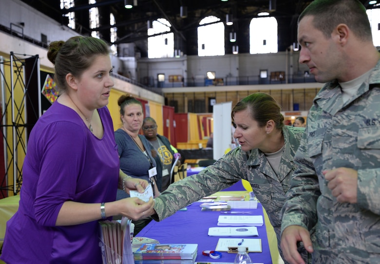 Chief Master Sgt. Vogel reaches for information from the child and youth program booth at Unity Day May 21 at the 5th Regiment Armory in Baltimore. Unity Day has existed since 2006. (Photo by Airman 1st Class Enjoli M. Saunders/RELEASED)