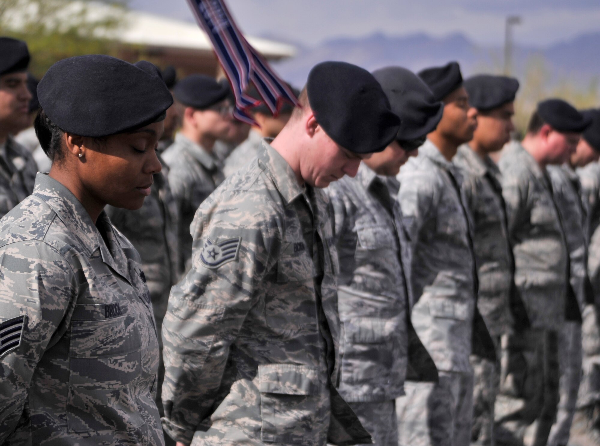 Members of the 799th Security Forces Squadron bow their heads during the Security Forces Prayer prior to a retreat ceremony May 14, 2015, at Creech Air Force Base, Nevada. The ceremony took place during National Police Week which honors fallen law enforcement officers who have paid the ultimate sacrifice. (U.S. Air Force photo by Airman 1st Class Christian Clausen/Released)