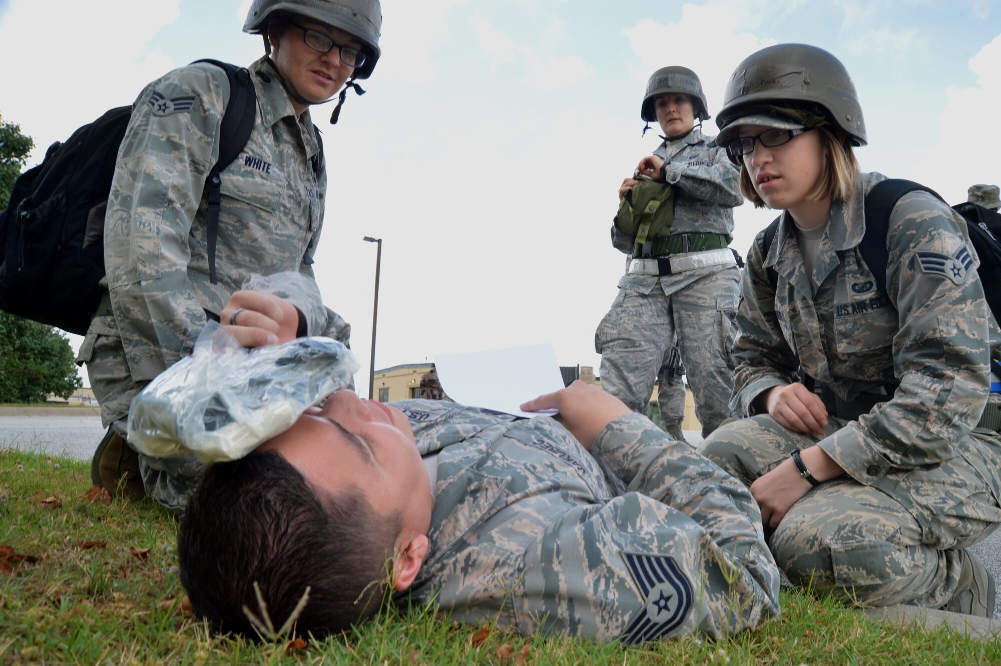U.S. Air Force Airmen assist Airman with a simulated injury during operational readiness exercise Weasel Victory 15-06 at Shaw Air Force Base, S.C., May 27, 2015. Throughout the ORE, Airmen must correctly respond to simulated injuries using proper self-aid buddy care techniques. (U.S. Air Force photo by Airman 1st Class Michael Cossaboom/Released)