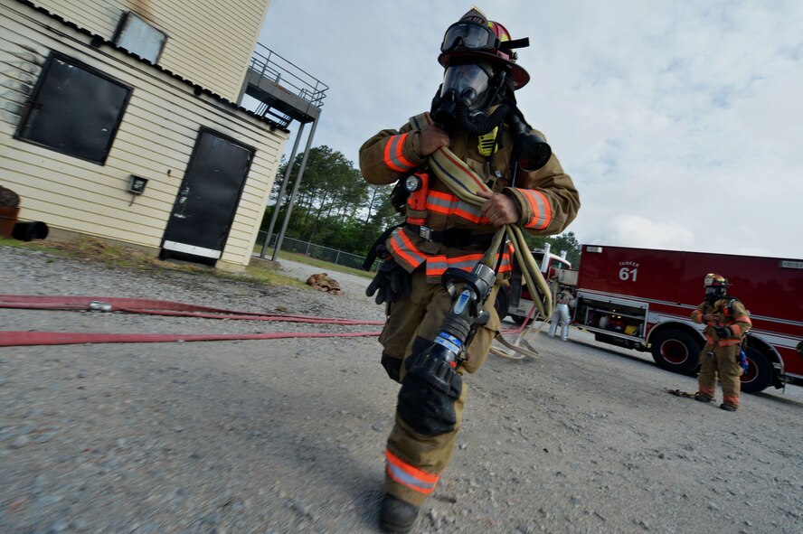 A U.S. Air Force Airman assigned to the 20th Civil Engineer Squadron pulls a hose in response to a simulated structural fire during operational readiness exercise Weasel Victory 15-06 at Shaw Air Force Base, S.C., May 27, 2015. The fire department was given seven minutes to respond to a simulated structural fire. (U.S. Air Force photo by Airman 1st Class Michael Cossaboom/Released) 