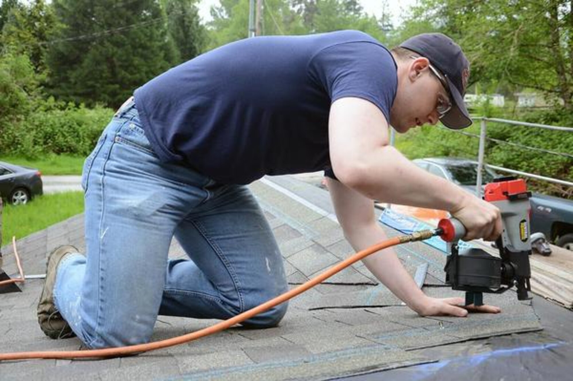 Staff Sgt. Adam Chmielowski, 1st Weather Squadron battlefield weather forecaster, reroofs a home in Graham, Wash., Tuesday. (U.S. Air Force photo/Senior Airman Jacob Jimenez) 
