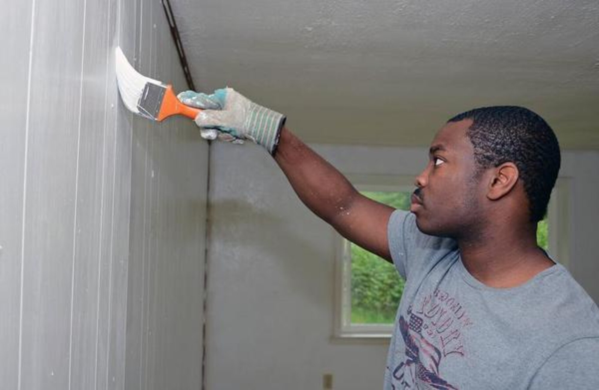 Staff Sgt. Dale Cain, 1st Weather Squadron battlefield weather forecaster, paints a wall at Habitat for Humanity home in Graham, Wash., Tuesday.(U.S. Air Force photo/Senior Airman Jacob Jimenez) 