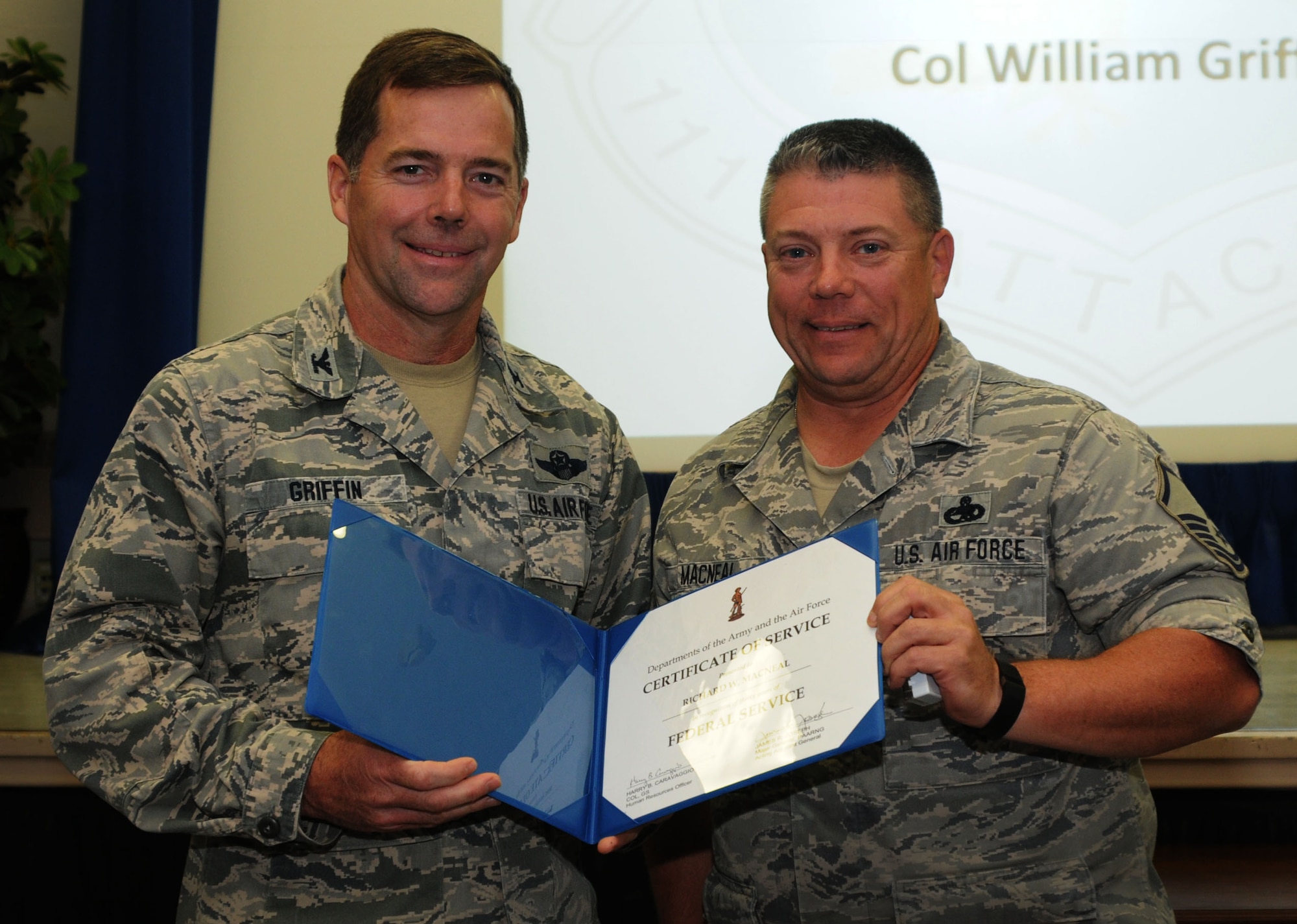 Vice Commander of the 111th Attack Wing Col. William R. Griffin presents Master Sgt. Richard MacNeal, 201st REDHORSE Squadron, Detachment 1, with the Department of the Army and Air Force Certificate of Service for 30 years of federal service on May 21, 2015, in the wing headquarters building, Horsham Air Guard Station, Pennsylvania. The acronym REDHORSE stands for Rapid Engineer Deployable Heavy Operational Repair Squadron Engineer squadrons; and they function as the Air Force's heavy-construction units. (U.S. Air National Guard photo by Tech. Sgt. Andria Allmond/Released)
