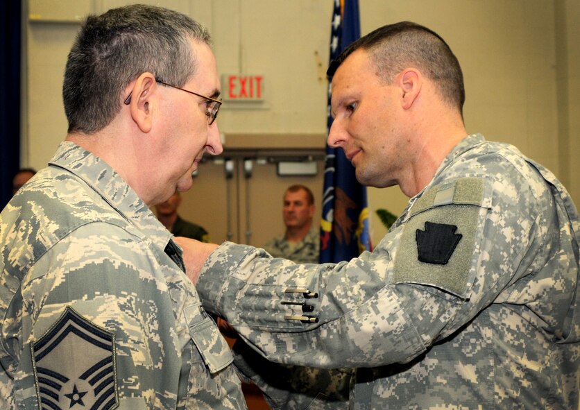 Maj. George Moebius, 56th Stryker Brigade Combat Team, 28th Infantry Division, Horsham Air Guard Station, Pennsylvania,  presents Senior Master Sgt. John Hertler of the 111th Attack Wing with the Army Commendation Medal by for his participation in Pa. Army National Guard’s Vigilant Guard exercise from May 10 – 15 last year, May 21, 2015, in the wing headquarters building, Horsham AGS. The 56th SBCT is one of nine Stryker Brigade Combat Teams in the United States Army and one of five brigades of the 28th Infantry Division. (U.S. Air National Guard photo by Tech. Sgt. Andria Allmond/Released)