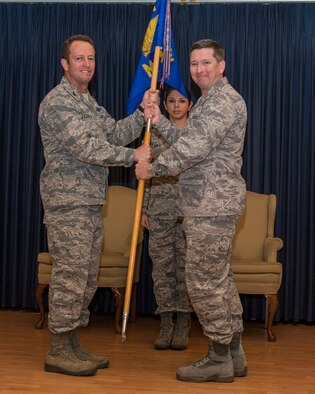 Col. Andrew Moore, 366th Medical Group commander, accepts the guidon from Col. David Iverson, 366th Fighter Wing commander, in an assumption-of-command ceremony at the Gunfighter Club at Mountain Home Air Force Base, May 26, 2015. Moore was previously the 779th Aerospace Medicine Squadron commander at Joint Base Andrews Air Force Base, Maryland and expressed his gratitude to be able to command the 366th MDG. (U.S. Air Force photo by Senior Airman Brittany Chase/RELEASED)