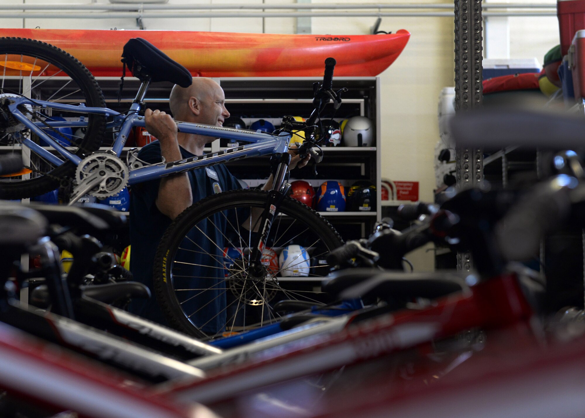 Mark Sturdevant, 31st Force Support Squadron Outdoor Recreation maintenance mechanic, carries a bike to an inspection table, May 26, 2015, at Aviano Air Base, Italy. Bicycles are regularly checked and maintained for the summer season. Outdoor Rec and the Information, Tickets and Travel office offer trips to take full advantage of the Italian and European experience. (U.S. Air Force photo by Airman 1st Class Cary Smith/Released)