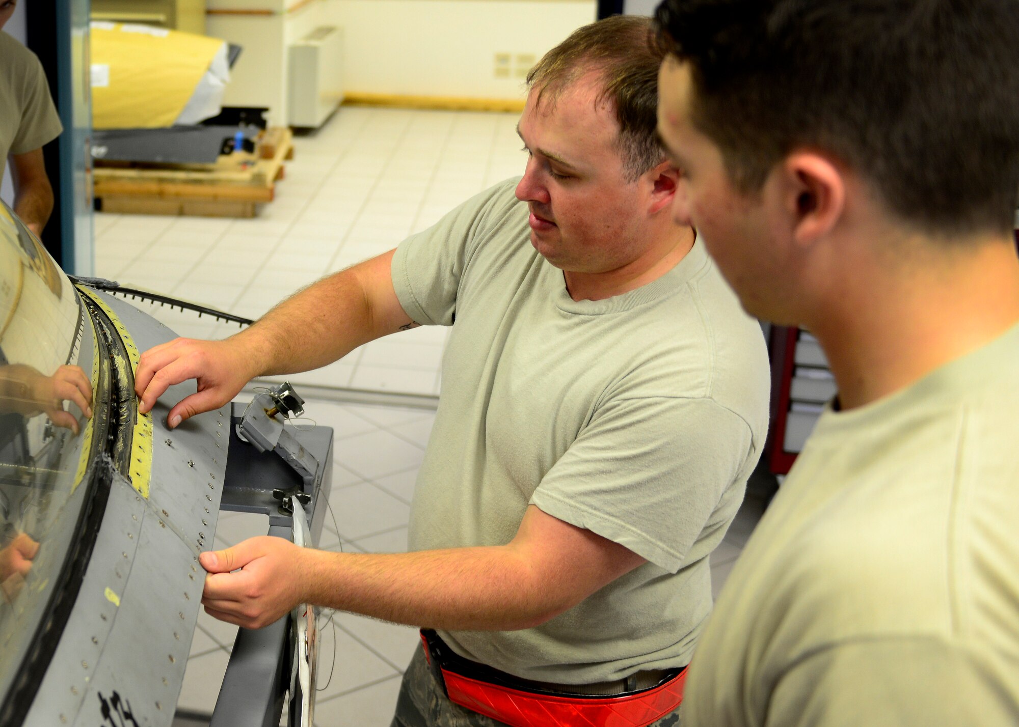 U.S. Air Force Senior Airman Eric Sturgis and Airman 1st Class Nicholas Perez, 31st Maintenance Squadron aircrew egress systems technicians, remove panels from a jet canopy, May, 27 2015, at Aviano Air Base, Italy. The technicians maintain aircraft egress components including, ejection seats, canopies and hatches. (U.S. Air Force photo by Senior Airman Areca T. Wilson/Released)