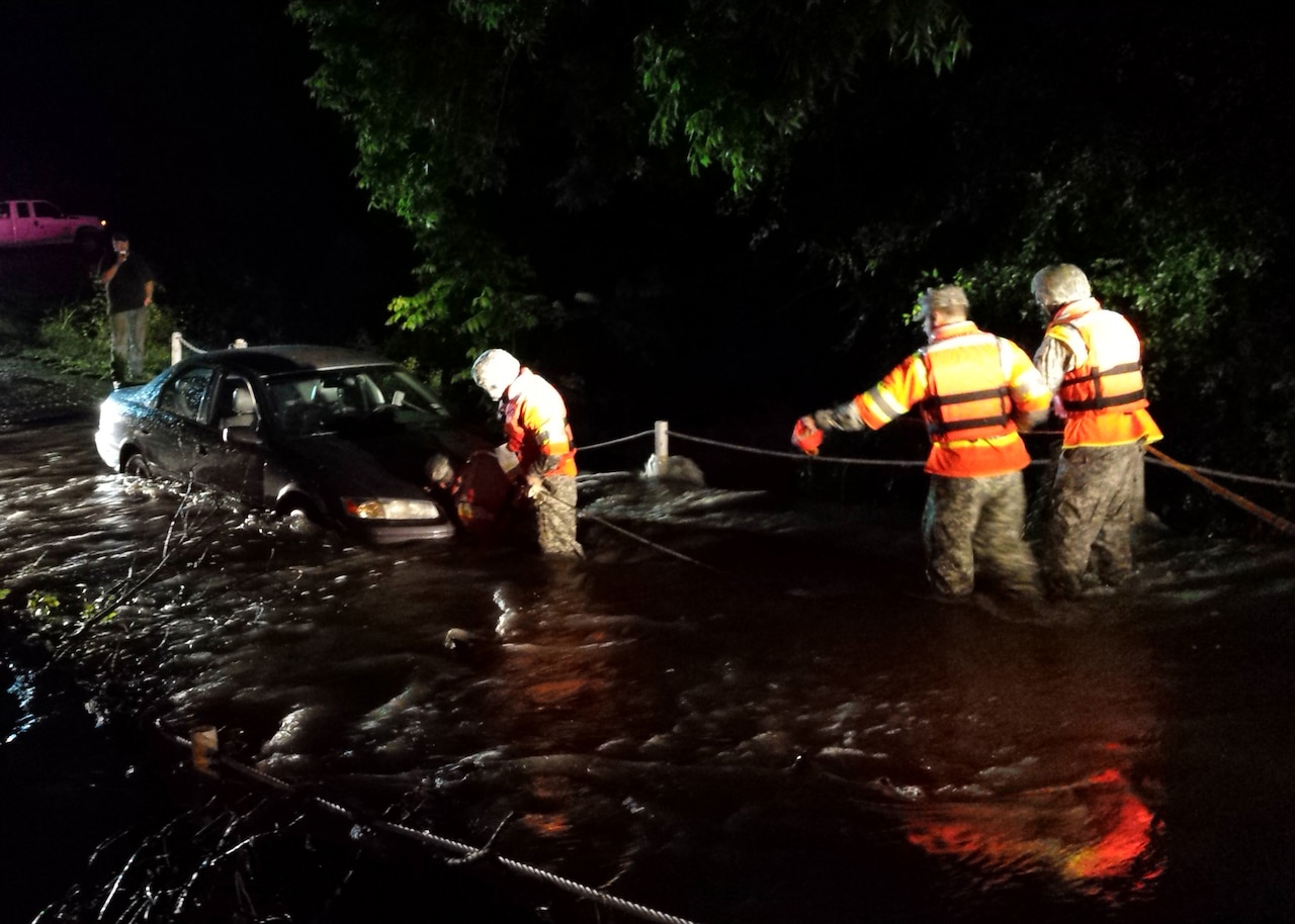 Working with first responders, engineers from the 111th Engineer Battalion of the Texas Army National Guard rescue three people from a stalled vehicle stuck in a low water crossing near Granbury, Texas, May 26, 2015. Texas Guardsmen have rescued more than 100 Texans in need during flooding across the state since mid-May. U.S. Army photo by 1st Lt. Max Perez