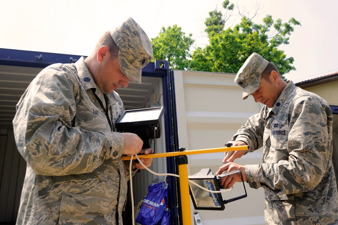 U.S. Air Force Lt. Col. Jason Lay, left, and U.S. Air Force Lt. Col. Jacob Skugrud assemble a lighting fixture to allow interior painting to continue at a water-damaged medical facility in the city of Mangalia, Romania, May 18, 2015. Lay is the commander of the 142nd Fighter Wing Civil Engineer Squadron, and Skugrud is the squadron's deputy commander. The project is part of U.S. European Command’s Humanitarian Civic Assistance Program.