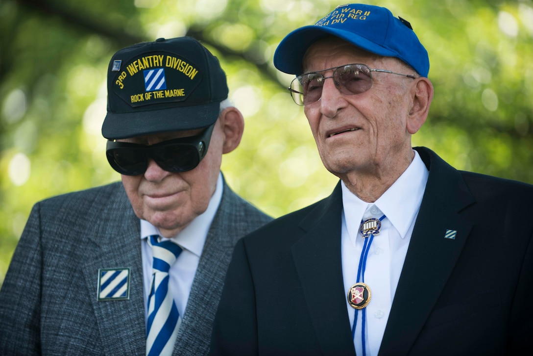 John Miller II, left, and John Keller, right, World War II veterans who were assigned to  the 3rd Infantry Division, gather to place flowers at Audie Murphy’s gravesite at Arlington National Cemetery in Arlington, Va., May 28, 2015. 