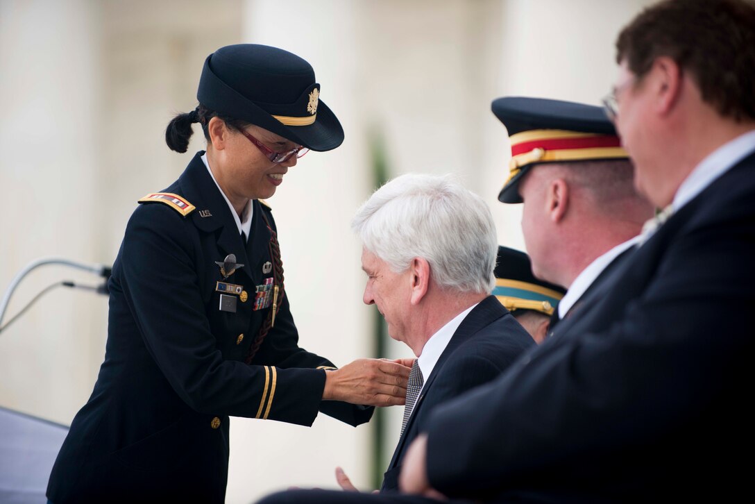 Host of the ceremony, U.S. Army retired Capt. C. Monika Stoy, left, president, Outpost 5845 International, Society of the 3rd Infantry Division, makes Ambassador Peter Manz, Embassy of Austria, an honorary member of the Society of the 3rd Infantry Division during the ceremony for the 70th Anniversary Commemoration of the Liberation of Salzburg and Austria in May 1945, in Arlington National Cemetery’s Memorial Amphitheater in Arlington, Va., May 28, 2015. 