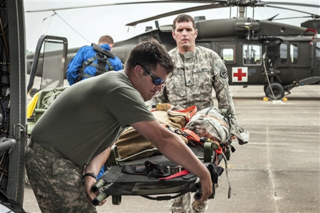 Army Sgt. Michael Hamilton, right, and Army Spc. Chris Sonnier load an UH-60 Black Hawk helicopter with rescue gear to prepare for swift-water rescues near Houston, Texas, May 17, 2015. Hamilton and Sonnier are flight medics assigned to the Louisiana National Guard. Since May, the guardsmen have rescued more than 100 people during flooding across the state.