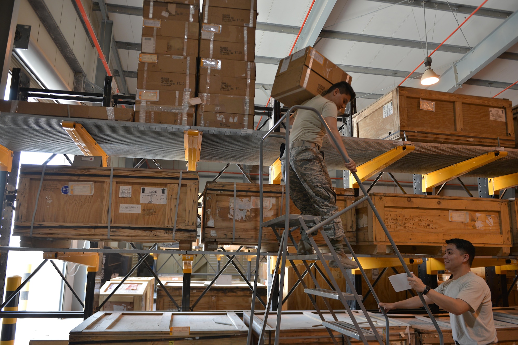 Airman 1st Class Lindsey McAlpin and Staff Sgt. Alan Nadal, 379th Expeditionary Logistics Squadron consolidated aircraft parts store, consolidate aircraft parts for shipment to a forward operating base May 21, 2015 at Al Udeid Air Base, Qatar. (U.S. Air Force photo/ Staff Sgt. Alexandre Montes)       