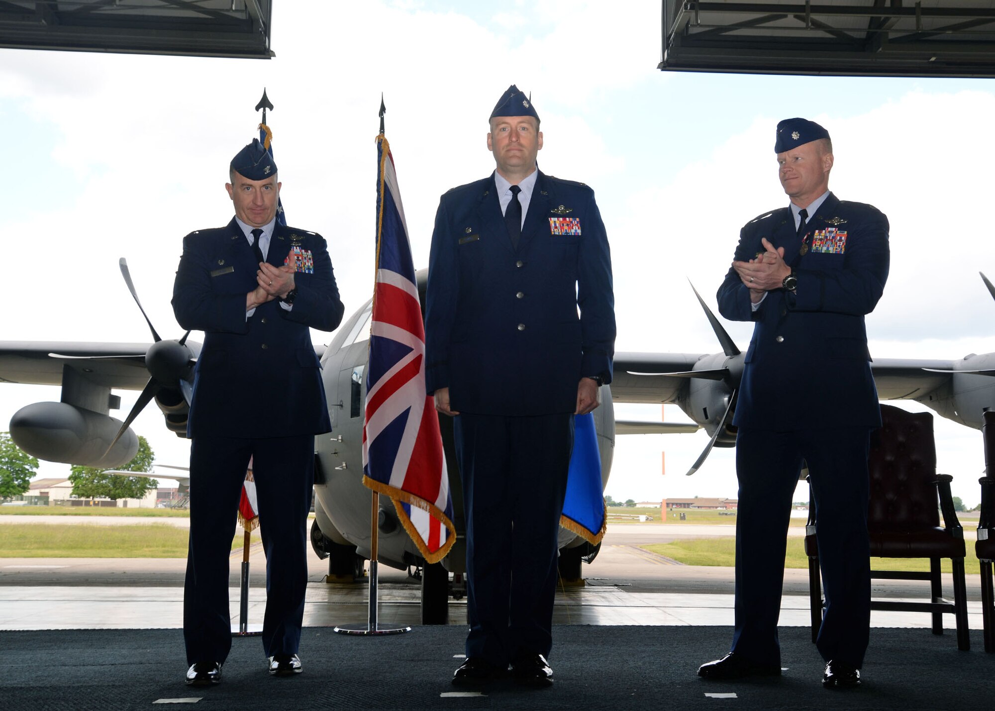 U.S. Air Force Lt. Col. Bradley C. Downs, center, officially becomes the new commander of the 67th Special Operations Squadron during the change of command ceremony May 28, 2015, in Hangar 803 on RAF Mildenhall, England. U.S. Air Force Col. Nathan C. Green, left, 752nd Special Operations Group commander and presiding official over the ceremony, and U.S. Air Force Lt. Col. John F. Peak, former commander of the 67th SOS, applaud as Downs takes command. The ceremony is a time-honored tradition in which one officer relinquishes command and passes it to another.(U.S. Air Force photo by Senior Airman Christine Halan)