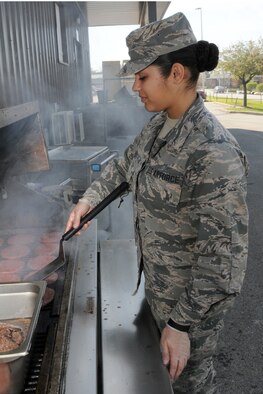 Air Force Reserve Airman Basic Monica White, a line cook assigned to the 910th Force Support Squadron, cooks burgers for the lunch meal on an outdoor grill just outside the Community Activity Center here, May 2, 2015. As part of their mission, the 910th FSS provides support in food service, lodging, fitness, recreation activities and self-help laundries during Unit Training Assembly weekends for YARS Service members, during the work week for Department of Defense employees and personnel working at the installation and during Annual Tour at YARS and deployed locations.