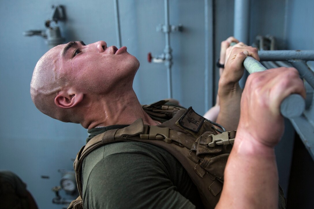 U.S. Marine Cpl. Kevin Ta does a pull-up to honor fallen service members during physical training aboard the USS Rushmore (LSD 47) at sea in the Pacific Ocean, May 25, 2015.  Kevin Ta is a team leader with Kilo Compnay, Battalion Landing Team 3rd Battalion, 1st Marine Regiment, 15th Marine Expeditionary Unit. In honor of Memorial Day, Marines with BLT 3/1 ran the ‘Memorial Day Murph’ challenge. The physical fitness event is named after Medal of Honor recipient U.S. Navy Lt. Michael P. Murphy. The challenge developed from Murphy’s daily work out routine, which consisted of a one-mile run, 100 pull-ups, 200 push-ups, 300 squats, and finishing with another one-mile run.  (U.S. Marine Corps photo by Sgt. Emmanuel Ramos/Released)