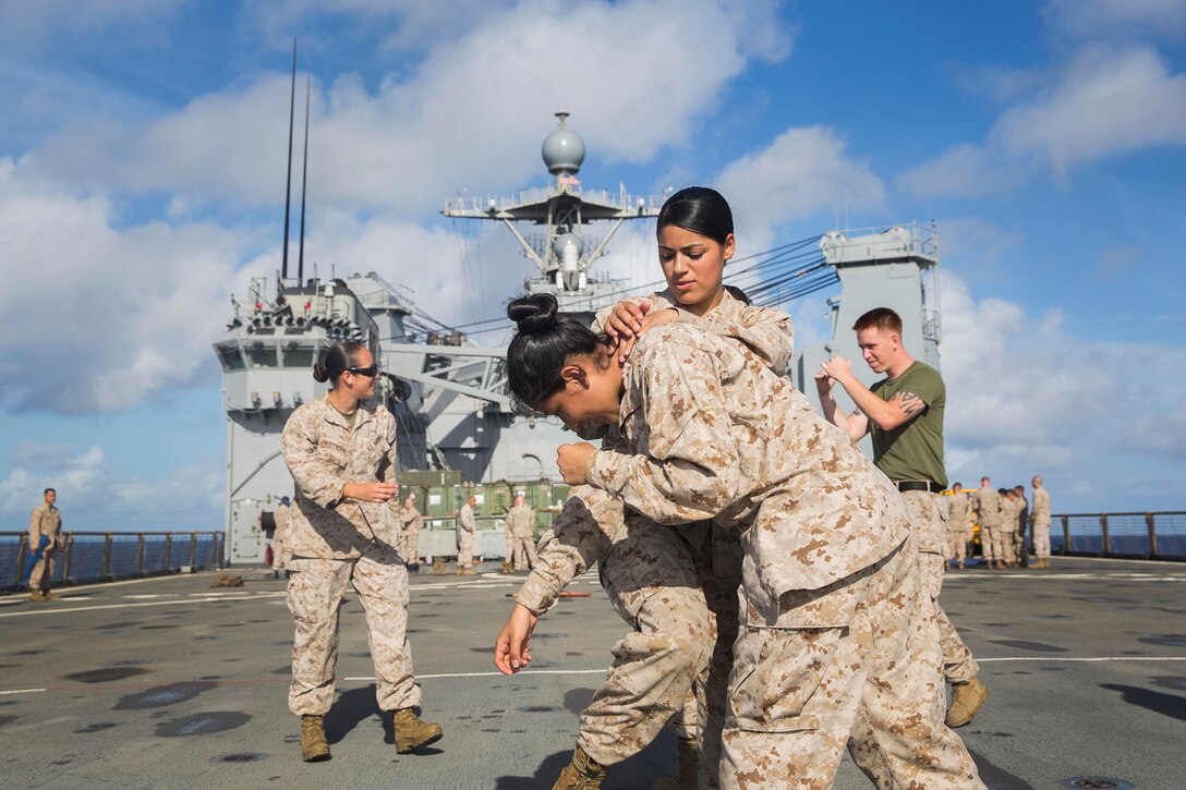 U.S. Marines Lance Cpl. Jasmine Castaneda, left, and Lance Cpl. Karina Navarro-Aguilera practice striking techniques during Marine Corps Martial Arts Program training aboard the USS Rushmore (LSD 47) at sea in the Pacific Ocean, May 26, 2015. MCMAP focuses on hand-to-hand combat training essential to mission readiness while deployed with the 15th MEU. (U.S. Marine Corps photo by Sgt. Emmanuel Ramos/Released)