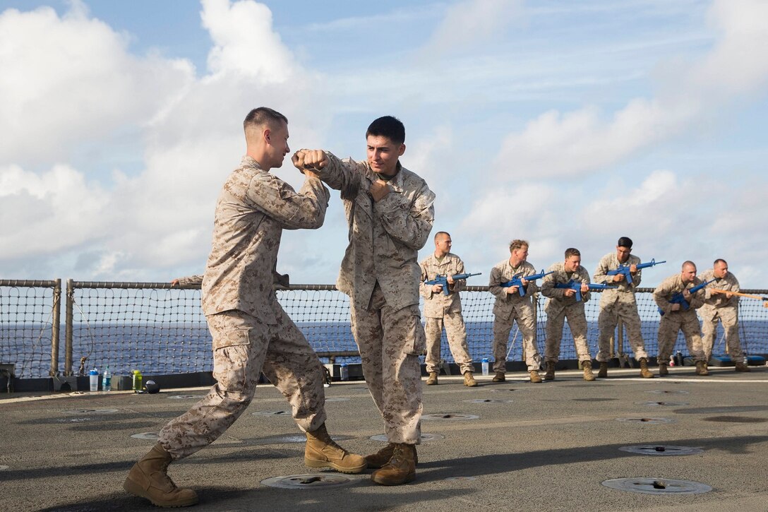 U.S. Marines Cpl. John Peterson, right, and Cpl. Oscar GarciaValadez practice blocking techniques during Marine Corps Martial Arts Program training aboard the USS Rushmore (LSD 47) at sea in the Pacific Ocean, May 26, 2015. Peterson and GarciaValadez are radio operators with Combat Logistics Battalion 15, 15th Marine Expeditionary Unit. MCMAP focuses on hand-to-hand combat training essential to mission readiness while deployed with the 15th MEU. (U.S. Marine Corps photo by Sgt. Emmanuel Ramos/Released)