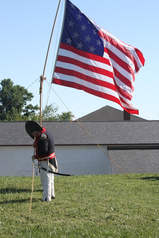 FORT NORFOLK, Va. -- A War of 1812 reenactor checks the flag here June 9, 2012. The reenactors were part of OpSail 2012, which marked the bicentennial of the War of 1812 and brought international tall ships and naval vessels to Hampton Roads and other port cities.  (U.S. Army photo/Kerry Solan)