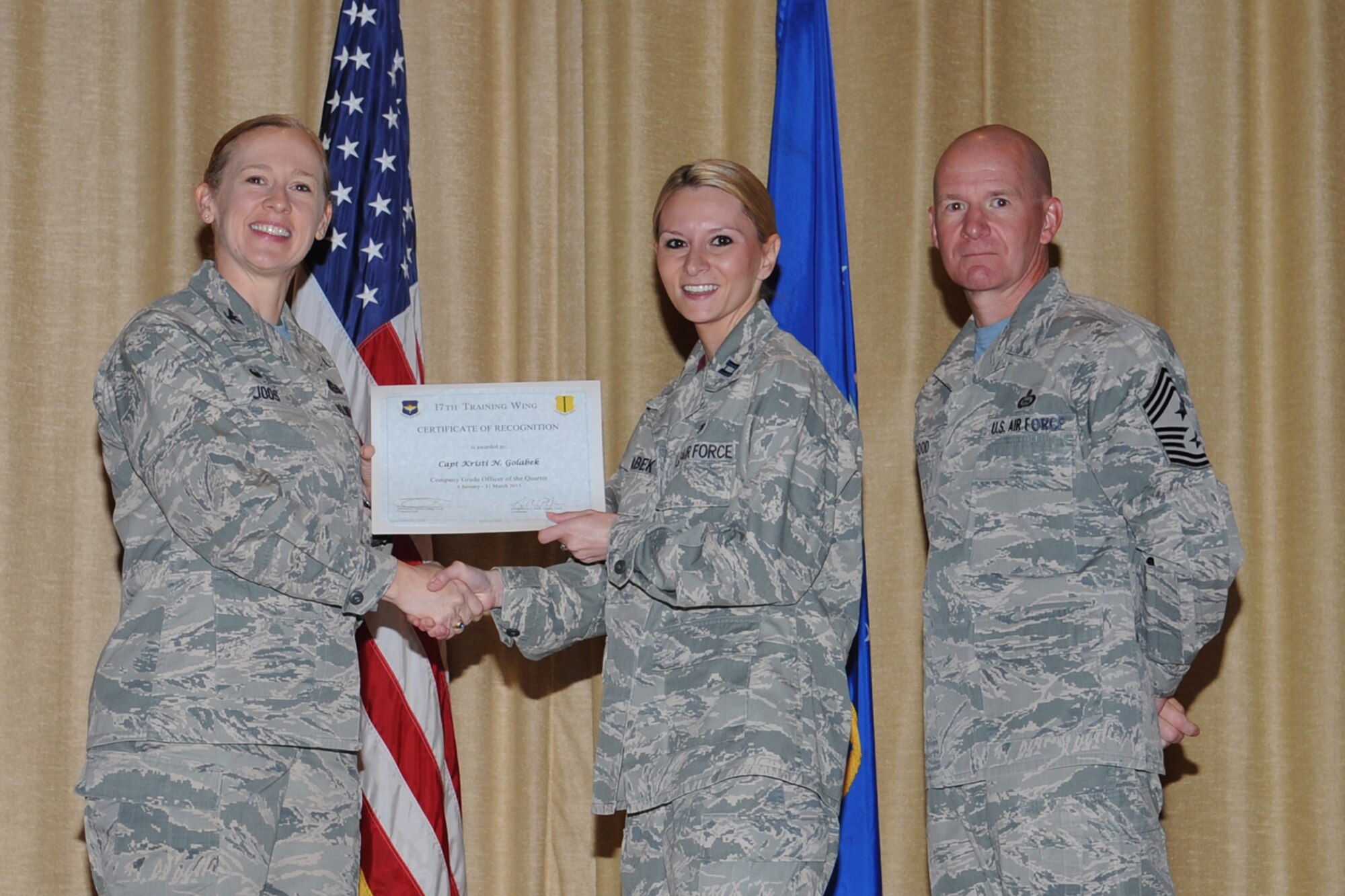 GOODFELLOW AIR FORCE BASE, Texas - Col. Kimberlee P. Joos, 17th Training Wing Commander, and Chief Master Sgt. Thomas F. Good, 17th TRW Command Chief, present the Company Grade Officer of the Quarter award to Capt. Kristi N. Golabek, 17th Medical Group, during the wing quarterly awards ceremony at the base theater April 24. (U.S. Air Force photo/ Staff Sgt. Laura R. McFarlane)
