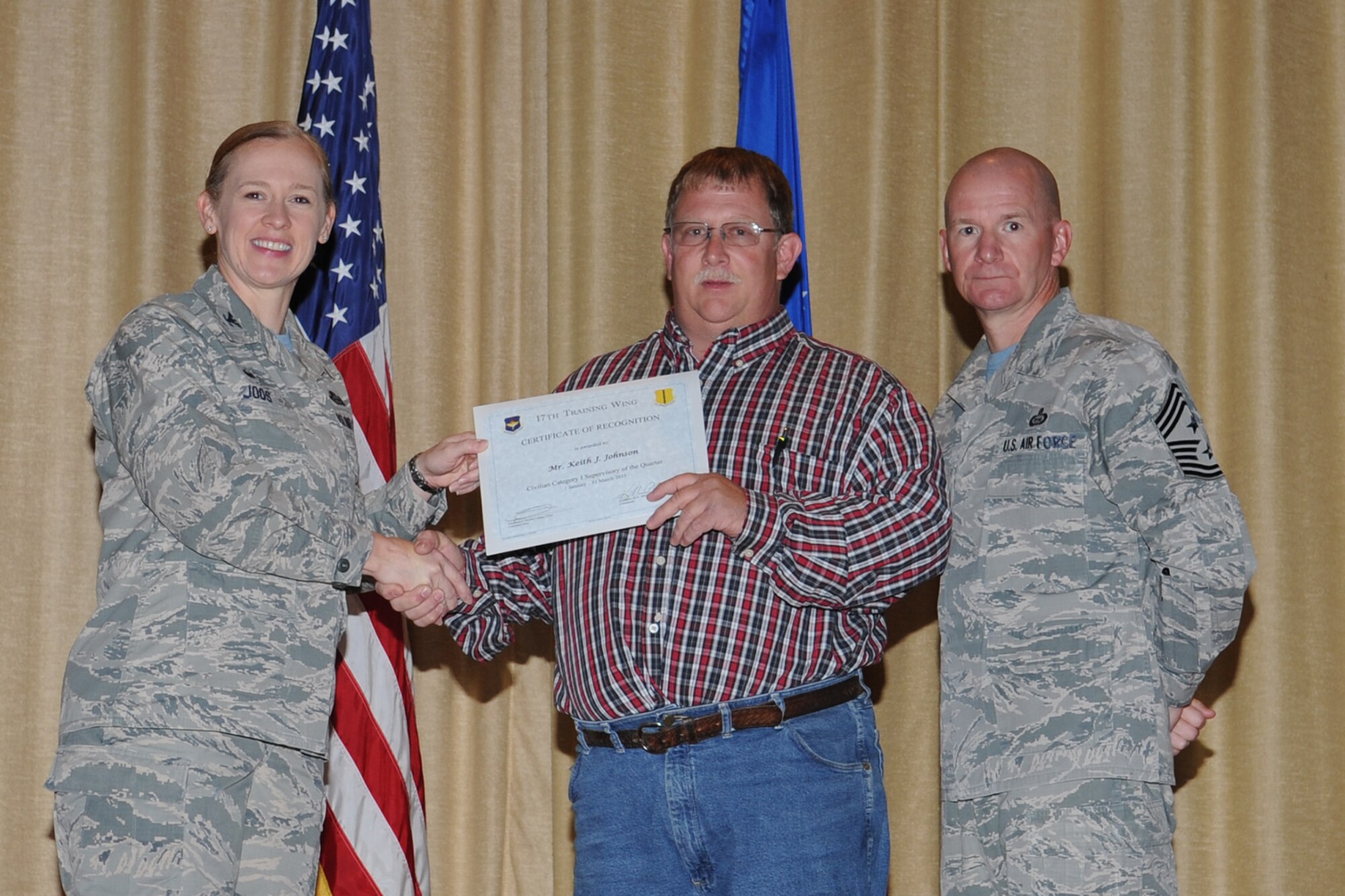 GOODFELLOW AIR FORCE BASE, Texas - Col. Kimberlee P. Joos, 17th Training Wing Commander, and Chief Master Sgt. Thomas F. Good, 17th TRW Command Chief, present the 17th Training Wing Civilian Category I Supervisory of the Quarter award to Keith J. Johnson, 17th Mission Support Group, during the wing quarterly awards ceremony at the base theater April 24. Johnson also received the Team Goodfellow Civilian Category I Supervisory of the Quarter. (U.S. Air Force photo/Staff Sgt. Laura R. McFarlane)