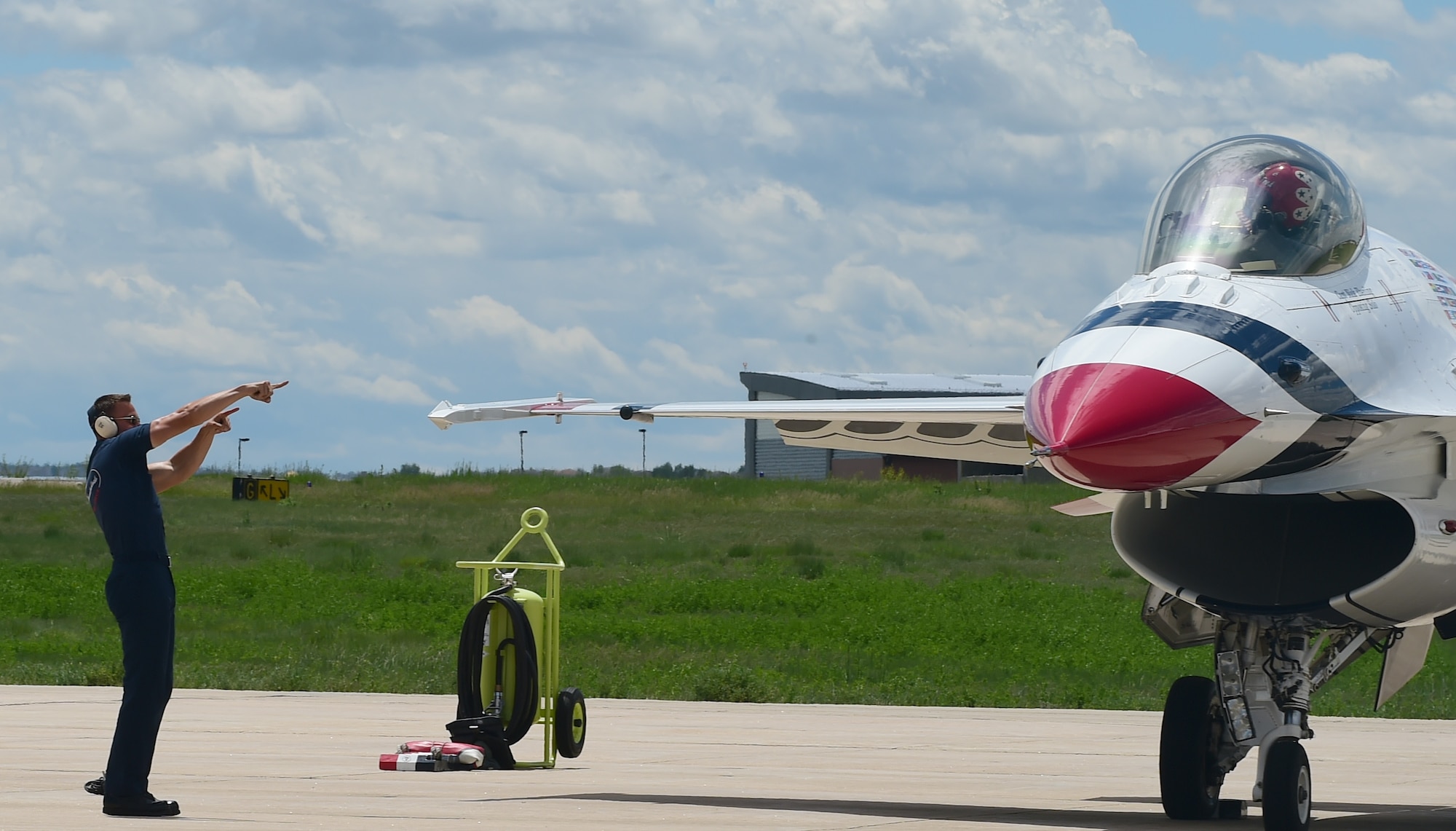 A crew chief marshals a Thunderbird F-16 Fighting Falcon May 29, 2015 on Buckley Air Force Base, Colo. The Thunderbirds are staging out of Buckley AFB for the up-coming Rocky Mountain Air Show. (U.S. Air Force photo by Airman 1st Class Luke W. Nowakowski/Released)