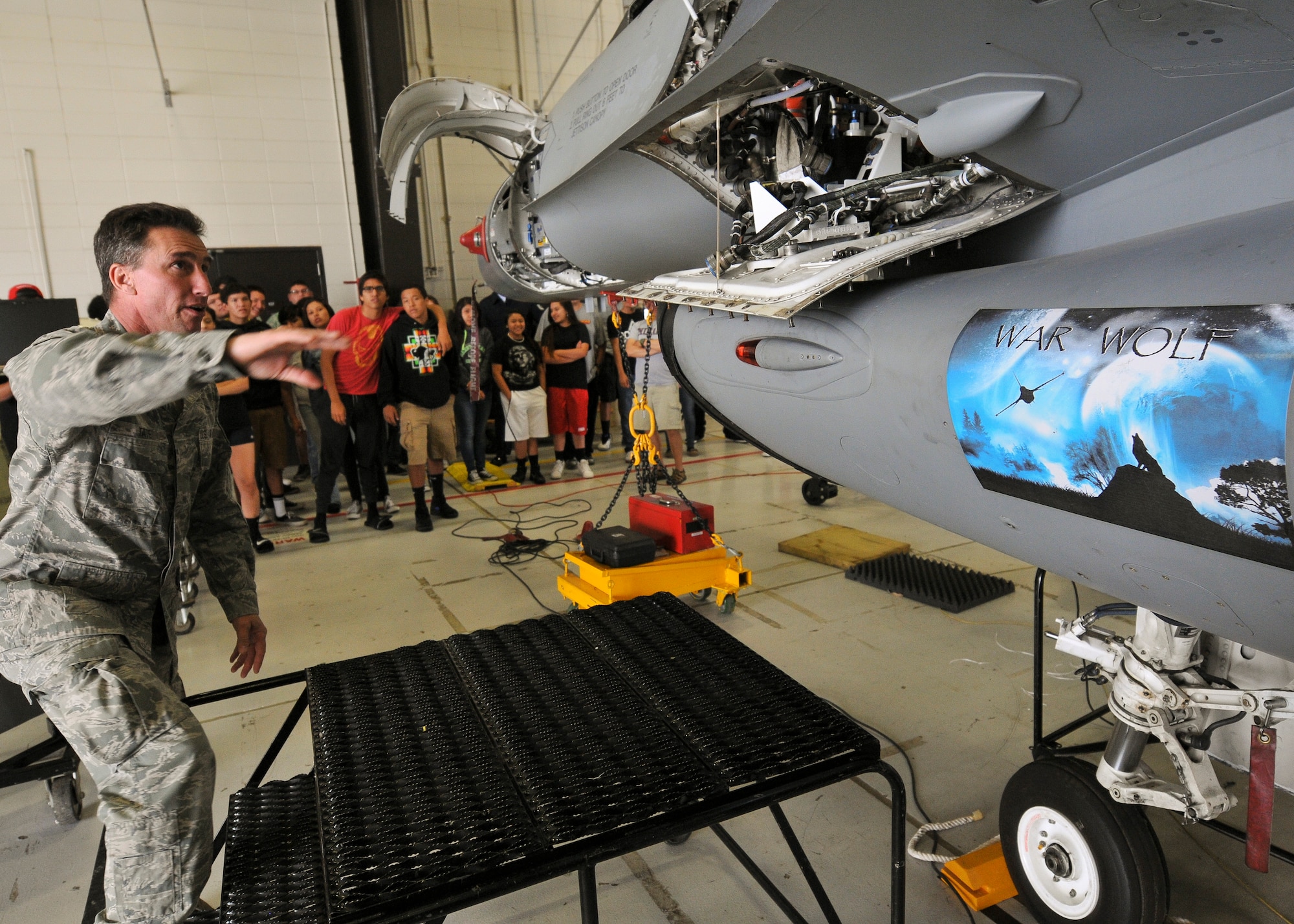 Master Sgt. Darrin Tate, 114th Aircraft Maintenance Squadron avionics technician, describes the basic functions of an F-16 Fighting Falcon to students from the Flandreau Indian School Summer Academy during a base tour of the 114th Fighter Wing in Sioux Falls, S.D., May 29, 2015. The students toured the 114th FW and were briefed about the many roles and specialized fields that make up the South Dakota Air National Guard.(National Guard photo by Staff Sgt. Luke Olson/Released)