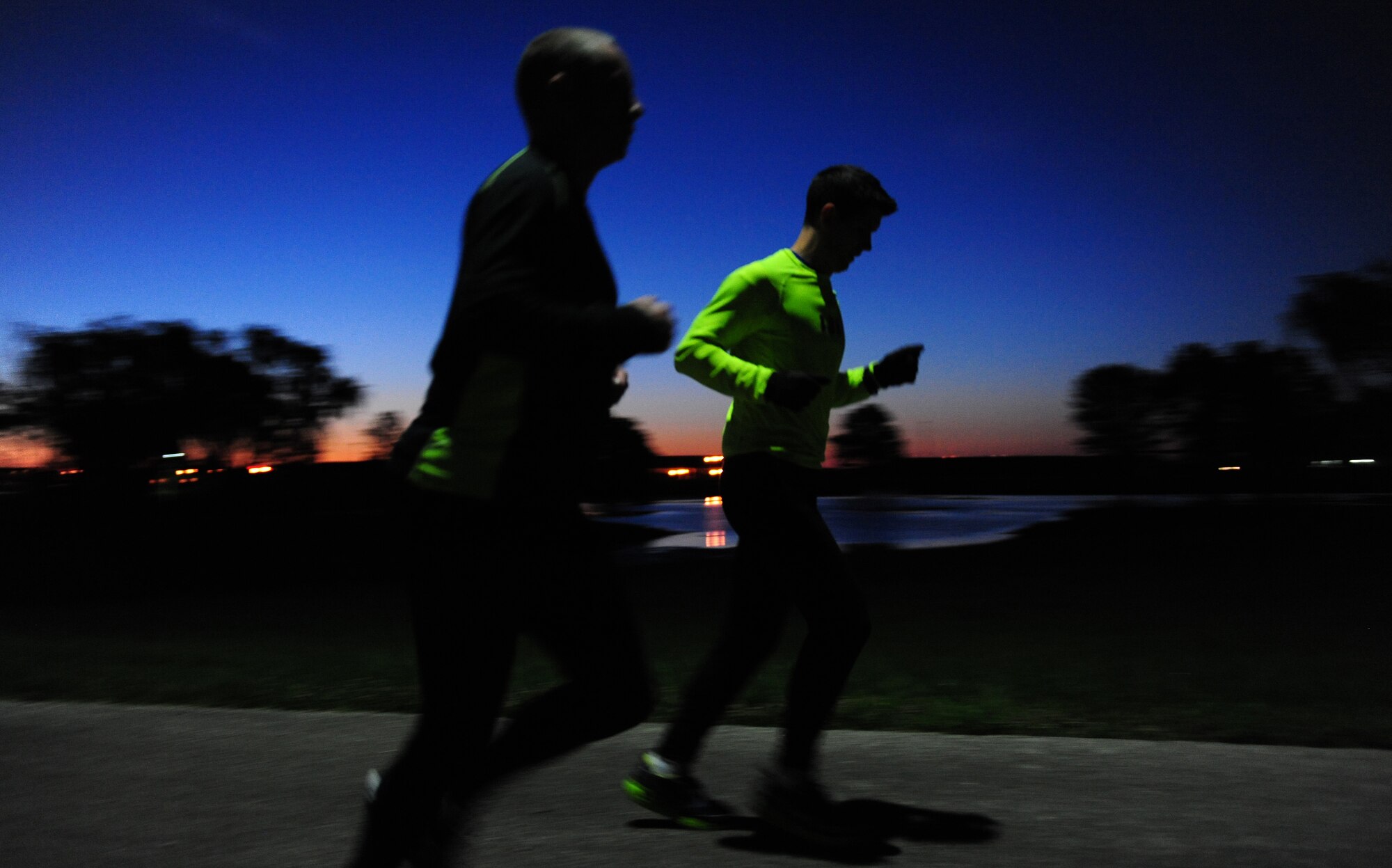 U.S. Air Force Staff Sgt. Brendan Brustad and 1st Lt. James Laughridge, both from the 509th Medical Support Squadron, run during the early hours of the day at Whiteman Air Force Base, Mo., May 19, 2015. Brustad ran 161 miles to honor the 161 victims of an EF5 tornado that happened May 22, 2011, in Joplin, Mo. (U.S. Air Force photo by Senior Airman Joel Pfiester/Released)
