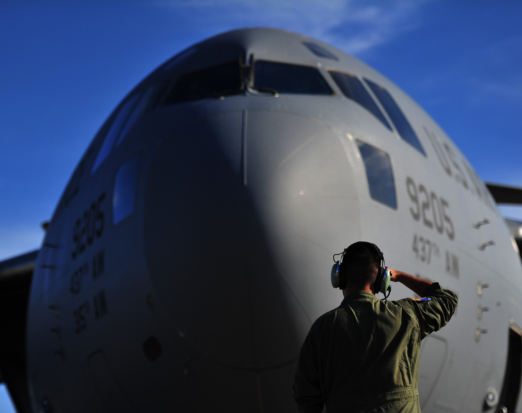 Airman 1st Class Matthew Link, 316th Airlift Squadron crew chief from Charleston Air Force Base, S.C., shields the sun from his face during pre-flight checks on a C-17 Globemaster, May 27, 2015, at Hurlburt Field, Fla. U.S. service members deployed to Honduras in support of NEW HORIZONS 2015, an annual event conducted to train military civil engineers and medical professionals to deploy and conduct joint operations. (U.S. Air Force photo by Airman 1st Class Ryan Conroy/Released)  