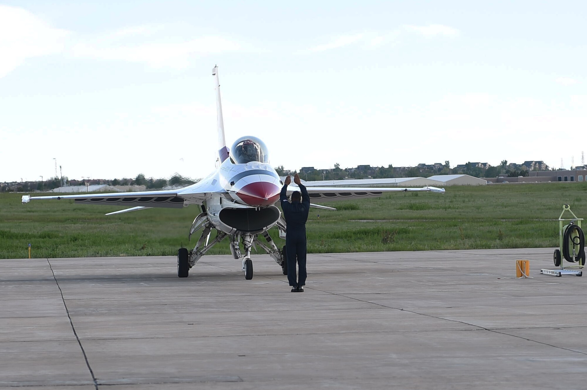 A Thunderbirds maintenance professional marshals a Thunderbirds jet onto the flight line May 28, 2015, on Buckley Air Force Base, Colo. The Thunderbirds team is staging out of Buckley AFB and will be performing in the 2015 Rocky Mountain Air Show May 30-31. (U.S. Air Force photo by Airman 1st Class Samantha Meadors/Released)