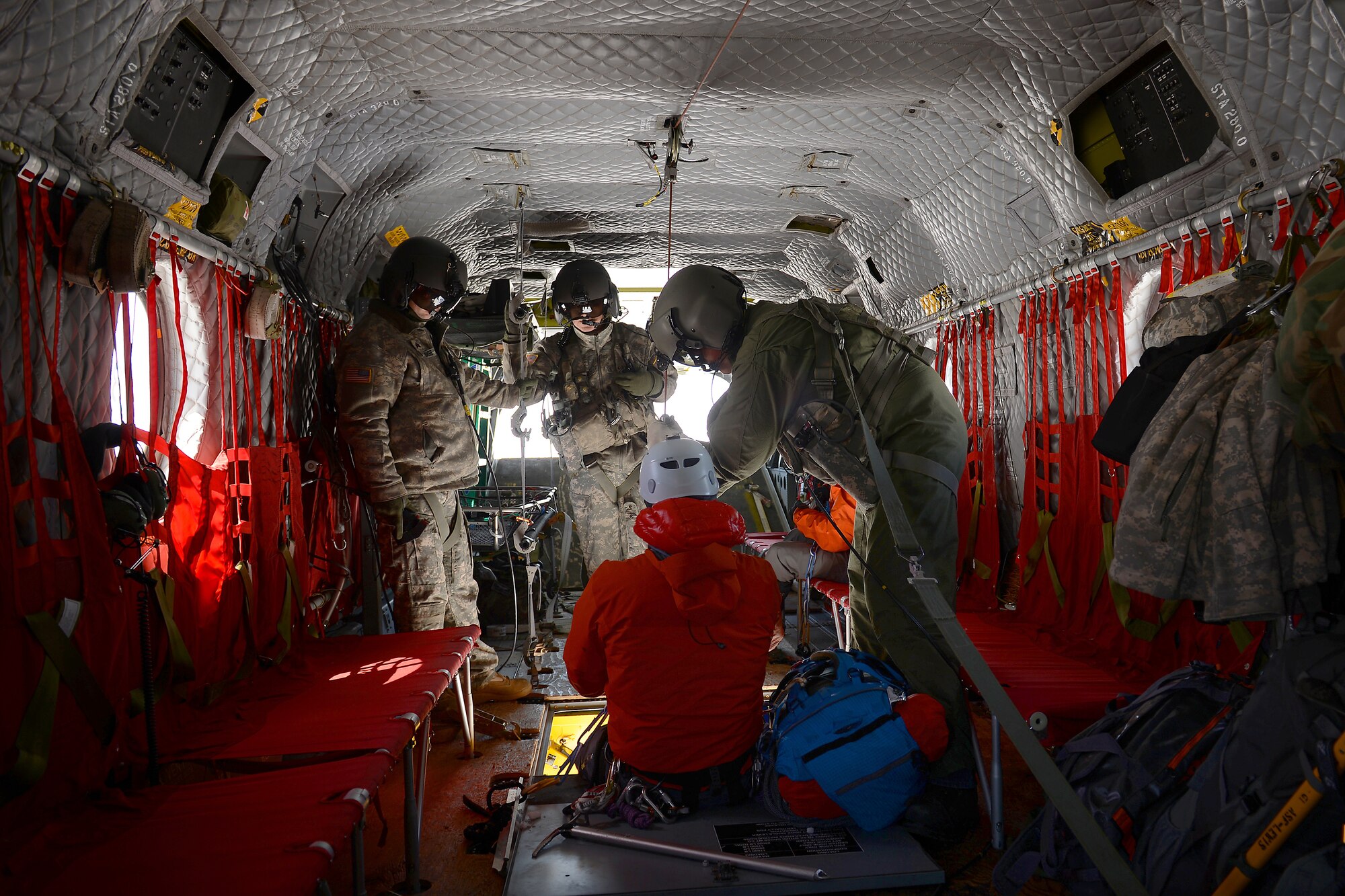 Soldiers from Bravo Co. 1-214th Aviation Regiment assist Tech. Sgt. Dean Criswell, 22nd Special Tactics Squadron NCOIC of rescue operations, into a CH-47 Chinook, May 15, 2015 on Mount Rainer, Wash. The 214th AR provides the aerial transportation for high altitude mountain rescues on Mount. Rainer. (U.S. Air Force photo by Staff Sgt. Tim Chacon) 