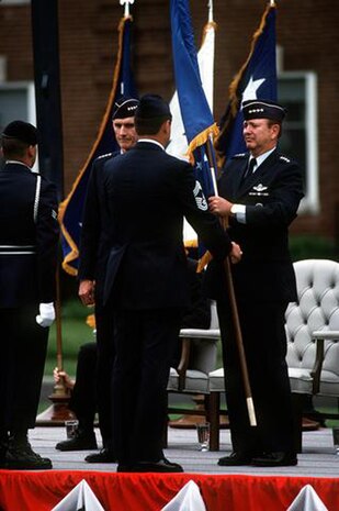 General H. T. Johnson, former commander of the Military Airlift Command, accepts the flag of the newly activated Air Mobility Command from Chief Master Sgt. David Campanale, senior enlisted advisor for the new command, June 1, 1992. Air Force Chief of Staff Gen. Merrill A. McPeak stands at left.  (U.S. Air Force photo by Technical Sergeant Dave Nolan)