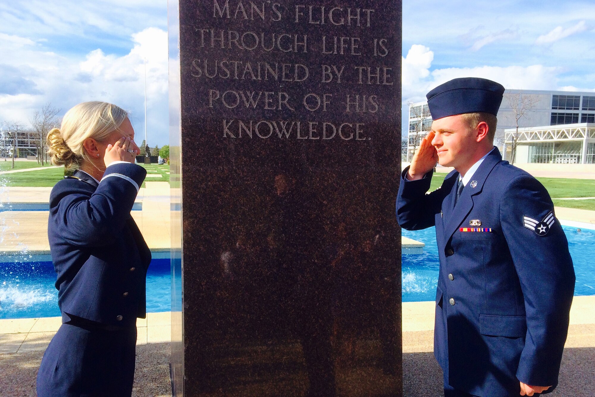 Senior Airman Justin Bishop, 48th Operations Support Squadron aircrew flight equipment journeyman, renders the Silver Dollar Salute to his sister, 2nd Lt. Courtney Bishop U.S. Air Force graduate, at the U.S. Air Force Academy, May 27, 2015. The Silver Dollar Salute has been a military tradition since the 19th century. Newly-commissioned officers give a silver dollar to the first enlisted member who salutes them. (Courtesy photo