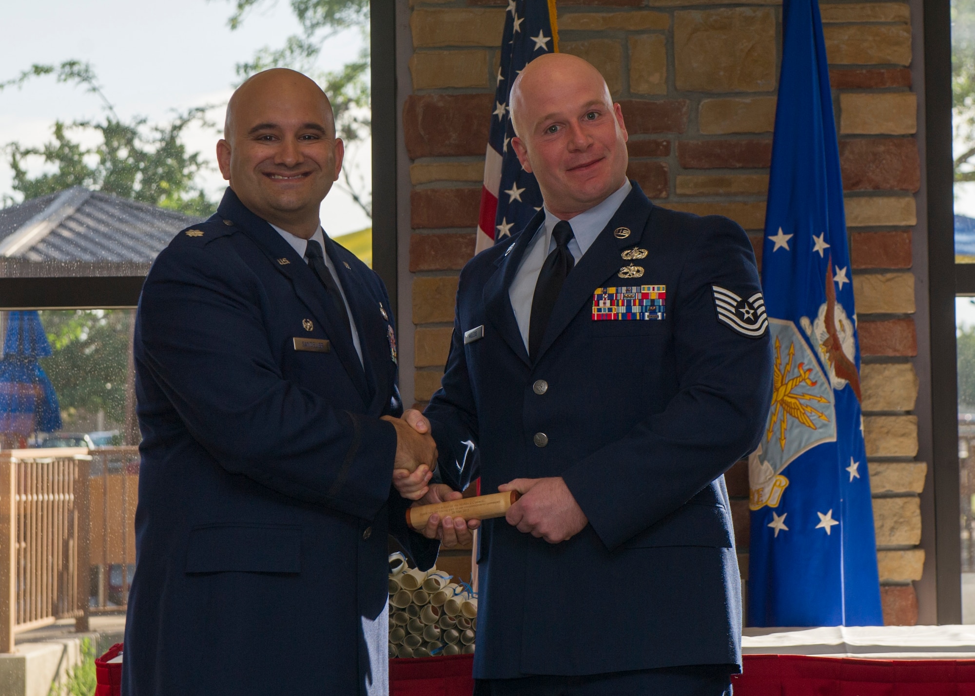 Technical Sgt. Dominic Moless, 49th Communications Squadron non-commissioned
officer in charge of plans and programming and president of the Middle Two,
presents a gift to Lt. Col. Matthew Sandelier, 49th Force Support Squadron
commander and guest speaker for the Community College of the Air Force
graduation ceremony at Holloman Air Force Base, N.M., May 28, 2015. Airmen
who successfully completed their CCAF degree were celebrated and awarded
their diploma by Lt. Col. Ryan Craycraft, 49th Wing vice commander. (U.S.
Air Force photo by Airman 1st Class Emily Kenney / Released)
