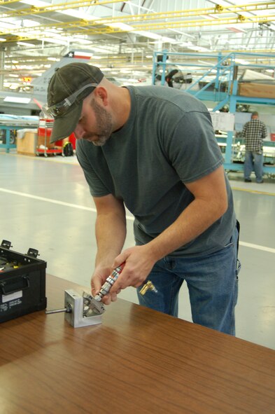 Mike Russell, a structures technician, assembles the blending tool used to blend F-16 repairs more accurately at precise depths to ensure structural integrity. The tool is an example of "The AFSC Way" pursuit of speed, safety and quality. (U.S. Air Force photo)