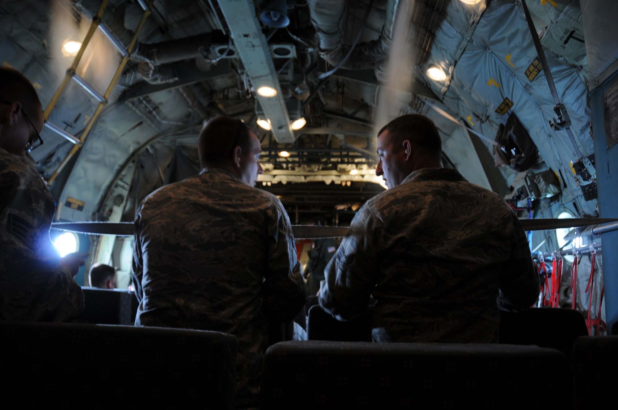 A picture of U.S. Air Force Senior Airman Michael Garcia and Senior Airman David Ringer, both from the 177th Civil Engineering Squadron, talking on a U.S. Coast Guard C-130 Hercules.