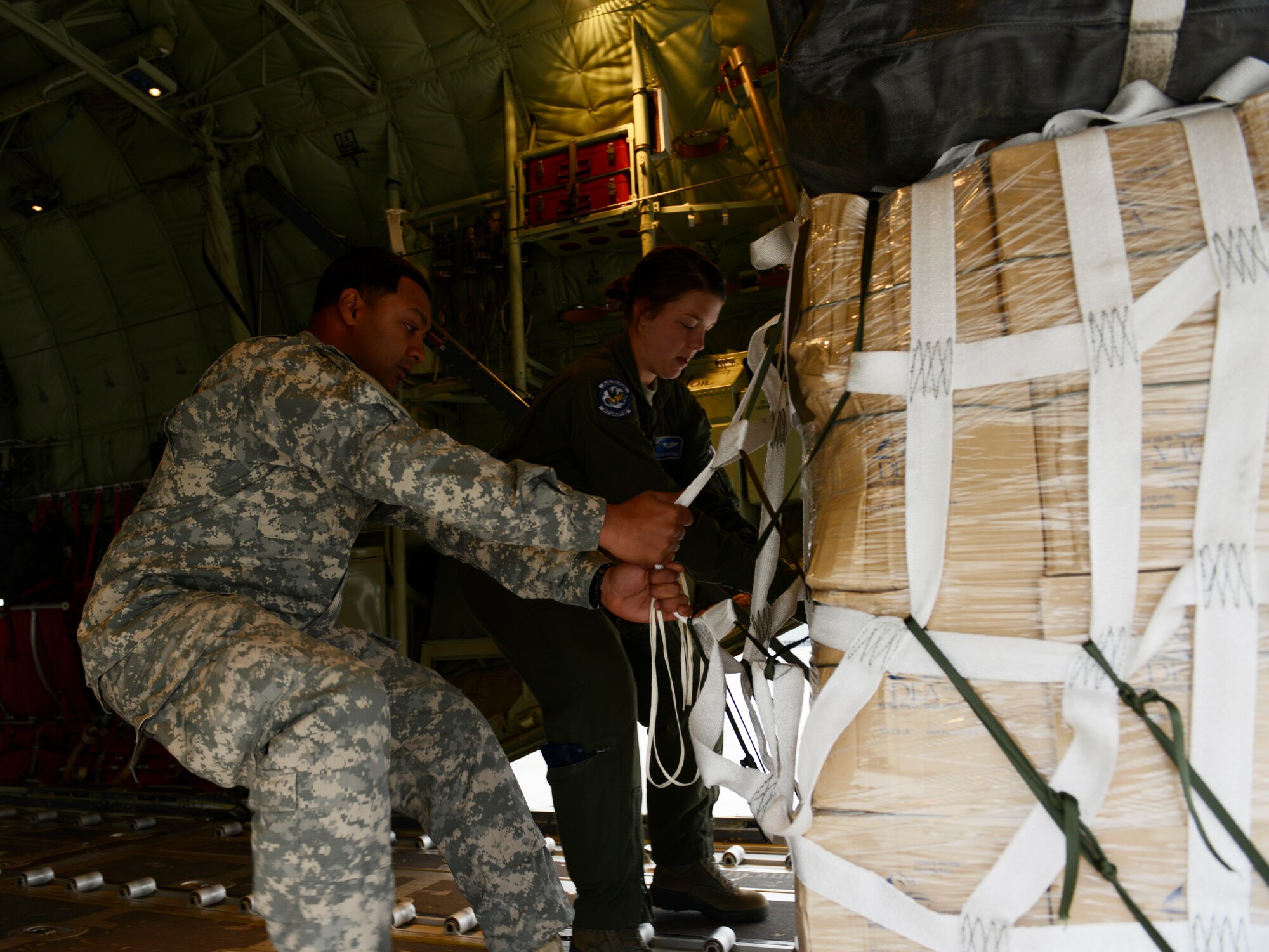 Army Staff Sgt. Neal Singh, 5th Quartermaster Company, Theatre Aerial Delivery Company, airdrop section chief, and Airman 1st Class Sarah Meadows, 37th Airlift Squadron loadmaster, pull a pallet onto a C-130J Super Hercules May 27, 2015, at Ramstein Air Base, Germany. The pallet and three others were dropped over Kosovo during an airdrop training exercise with the 37th Airlift Squadron. (U.S. Air Force photo/Airman 1st Class Tryphena Mayhugh)