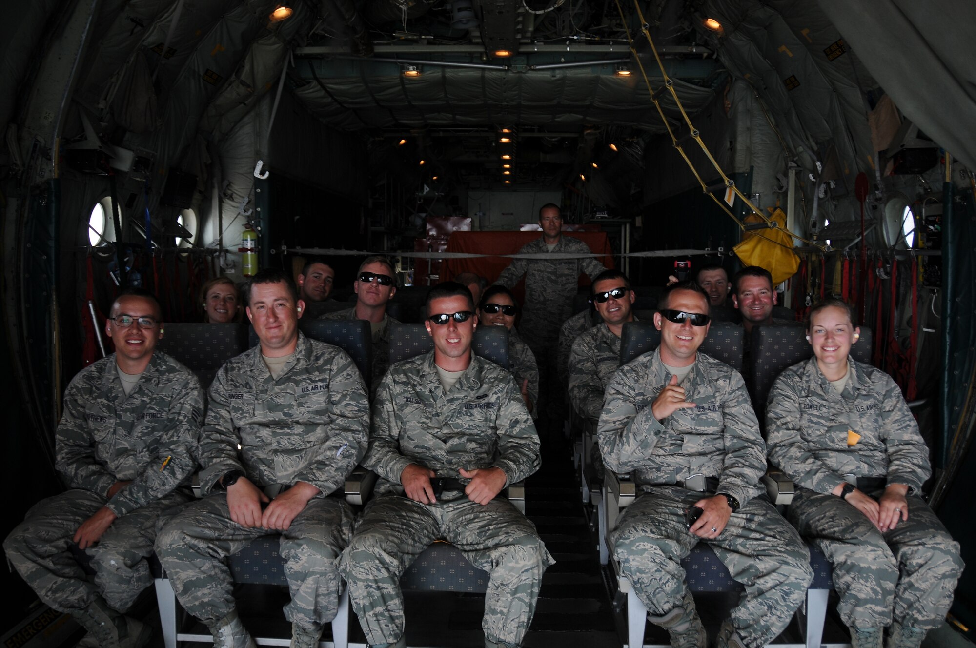 A picture of a group of Airmen looking out from a Coast Guard C-130 Hercules