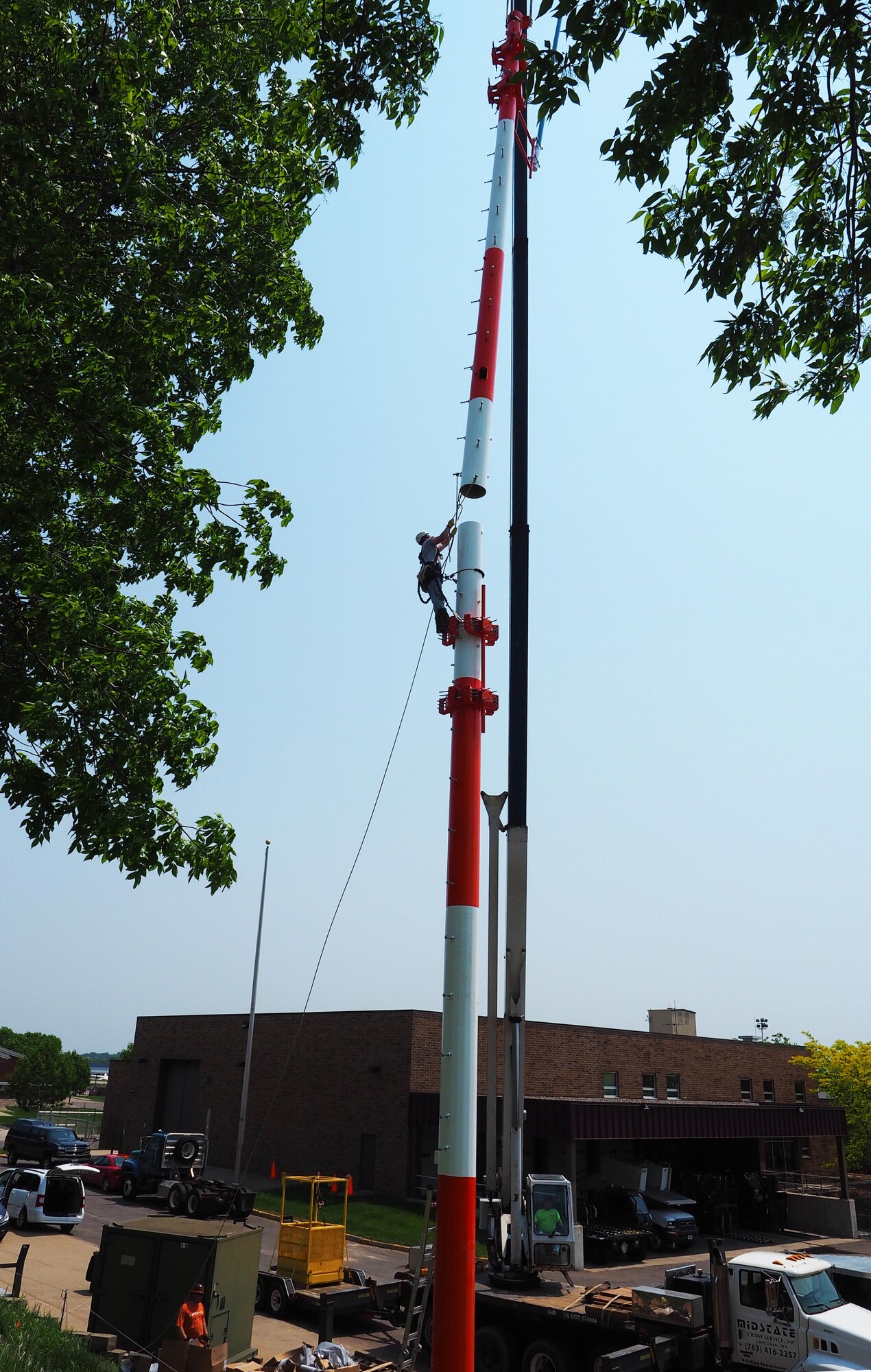 Contractors install a new enterprise land mobile radio tower May 27 at the 934th Airlift Wing.  The tower will enable secure mobile radio transmissions between Air Force Reserve bases and also state emergency services. (Air Force Photo/Paul Zadach)