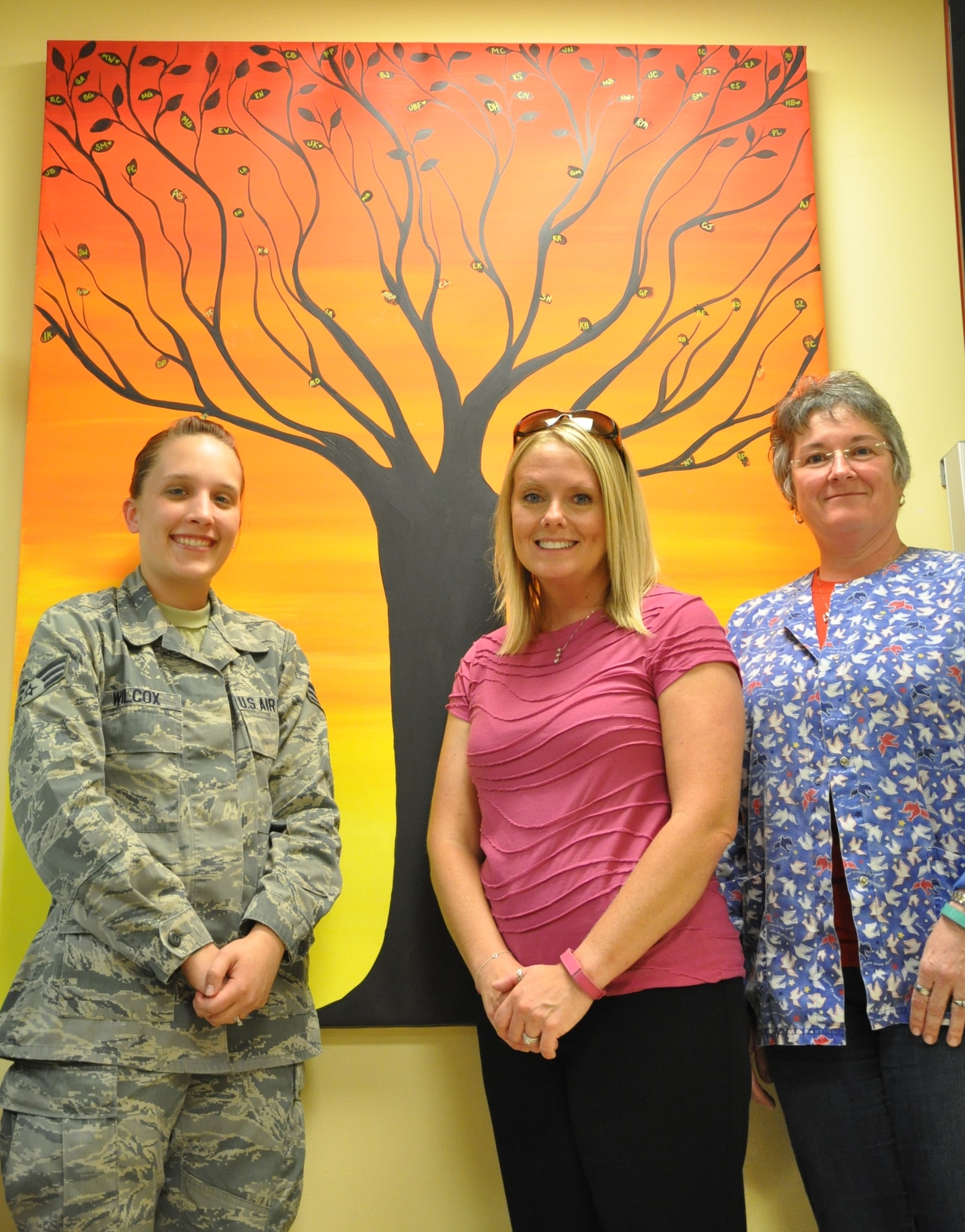 Senior Airman Kyleigh Wilcox (left), Alexis Joseph, and Cynthia Habegger initiated The Legacy Tree project at the Wright-Patterson Air Force Base Medical Center's Cancer Center. The project offers cancer center patients hope and to reassure them that they are not alone during their treatment. (Air Force photo by Gina Marie Giardina)