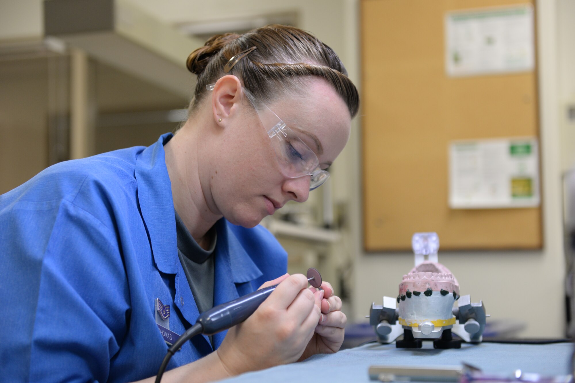 U.S. Air Force Staff Sgt. Marie Thomas, 18th Dental Squadron dental lab technician, polishes a metal dental crown on Kadena Air Base, Japan, May 29, 2015. The 18th DS is home to the second largest Area Dental Lab in the Air Force, which produces prosthetic devices such as dental crowns, night guards and dentures to the patients of more than 200 doctors across the Pacific Command. (U.S. Air Force photo by Senior Airman Omari Bernard)