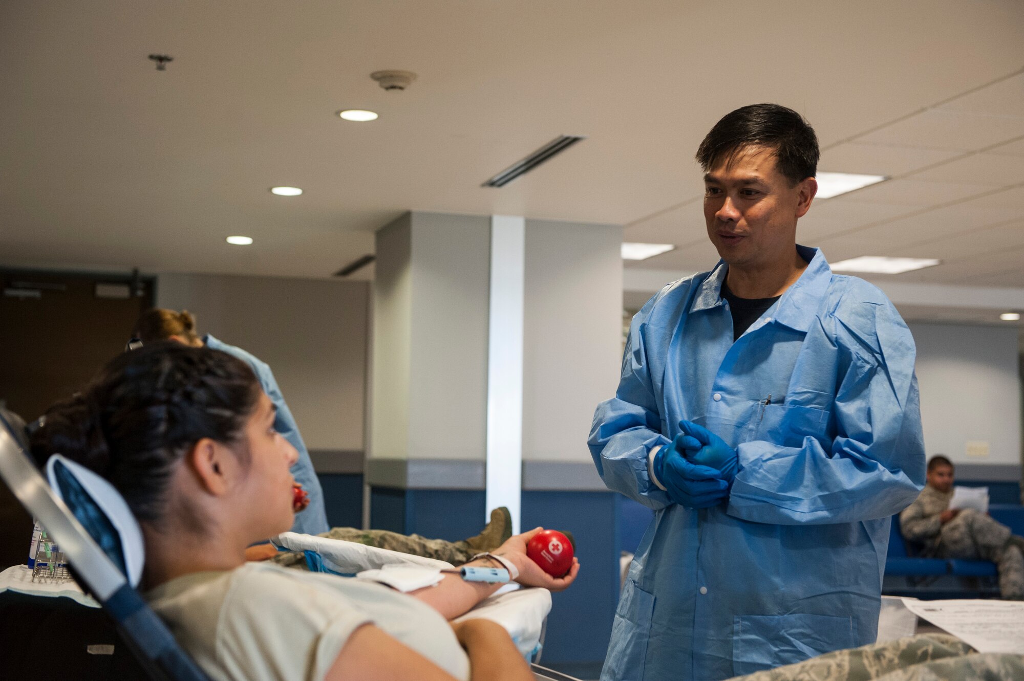 U.S. Navy Petty Officer 1st Class Christian Lacson, U.S. Naval Hospital, Okinawa, laboratory technician, speaks to U.S. Air Force Senior Airman Katrina Alvarez, 733rd Air Mobility Squadron aircraft services specialist, about donating blood during the Pacesetter post-Memorial Day blood drive on Kadena Air Base, Japan, May 29, 2015. One pint of blood can save up to three lives, and the blood drive is a way for military members to help give to those in need. (U.S. Air Force photo by Senior Airman Stephen Eigel)