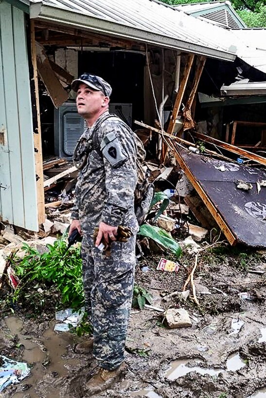 A Texas National Guard Soldier Searchs Through Debris, Vehicles And ...