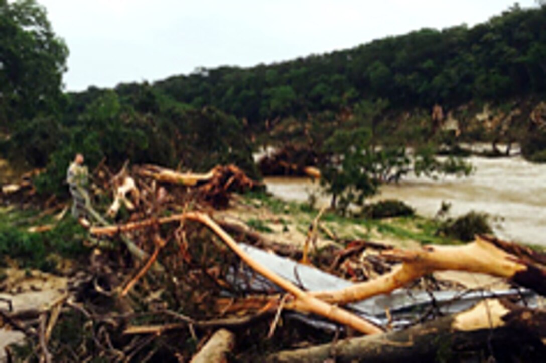 A Texas National Guard soldier searchs through debris during a search-and-rescue mission conducted along the Blanco River in the Hill Country of Texas, May 25, 2015.