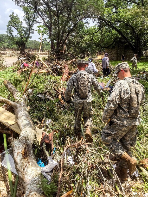 Soldiers and members of Texas Task Force 1 search through debris, vehicles and homes swept away by the flood water during a search-and-rescue mission conducted along the Blanco River in the Hill Country of Texas, May 26, 2015. The soldiers are assigned to the Texas Army National Guard's 1st Squadron, 124th Cavalry and D Company, 949th Brigade Support Battalion.