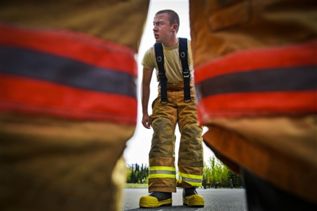U.S. Air Force Academy Cadet Kyle Barboza dons protective equipment during a visit with airmen on Joint Base Elmendorf-Richardson, Alaska, May 20, 2015, to learn about firefighting and rescue techniques under demanding conditions. The cadets are studying civil engineering at the academy. The airmen are assigned to the 673rd Civil Engineer Squadron. 