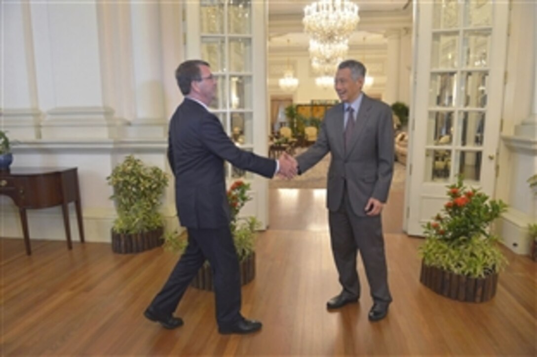 U.S. Defense Secretary Ash Carter, left, shakes hands with Singaporean Prime Minister Lee Hsien Loong before a meeting in Singapore, May 29, 2015.